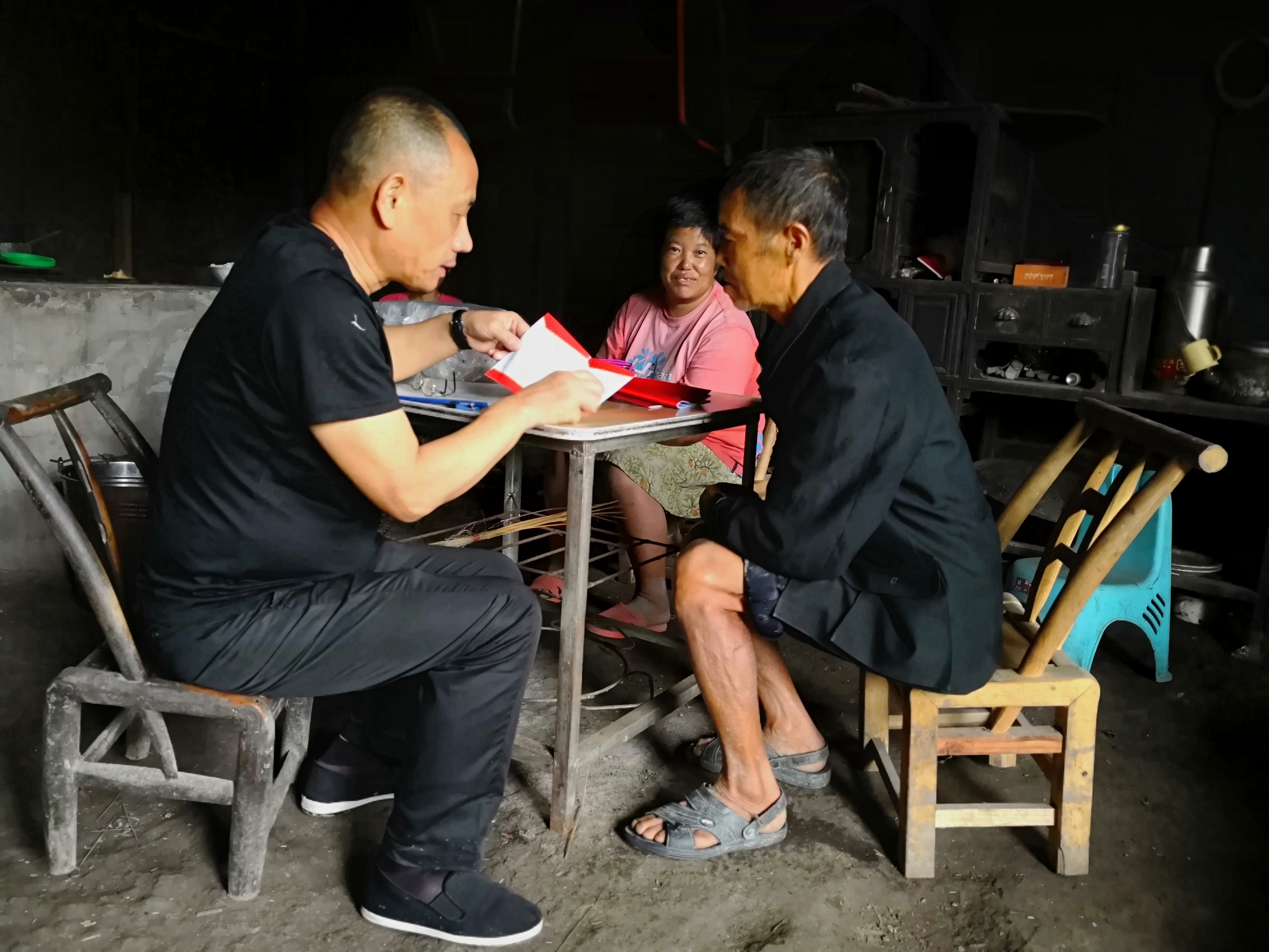 市粮食局调研员柴同勤向村民李松柏宣传扶贫政策.jpg